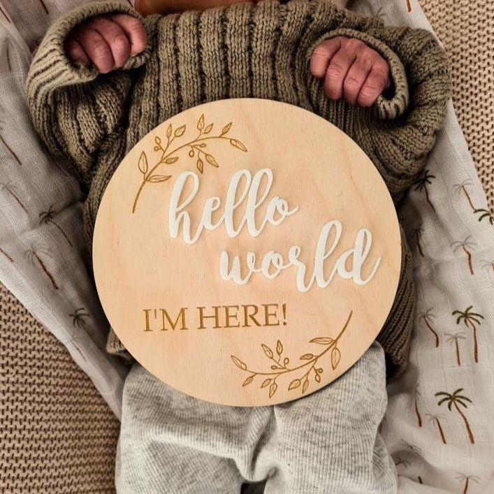 Hello World I'm Here pictured on a Baby