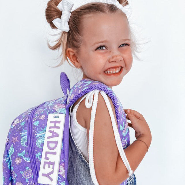 Girl holding Smiggle Bag with My Luxeve Bag Tag